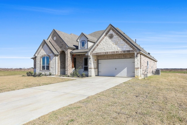 view of front of property with a front yard, a garage, and central AC unit