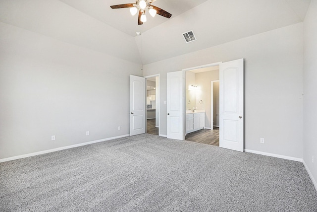 unfurnished bedroom with ceiling fan, ensuite bathroom, high vaulted ceiling, and dark carpet