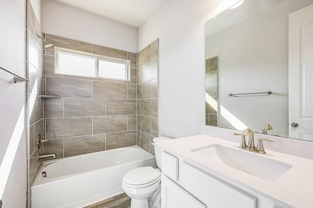 full bathroom with vanity, toilet, wood-type flooring, and tiled shower / bath