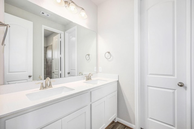 bathroom with vanity, hardwood / wood-style flooring, and walk in shower