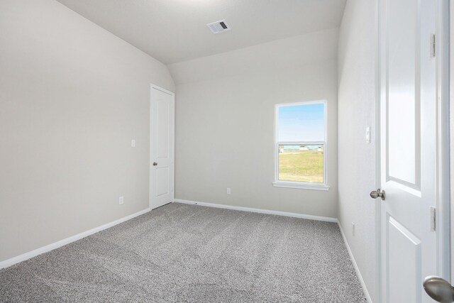 unfurnished room featuring carpet flooring and lofted ceiling