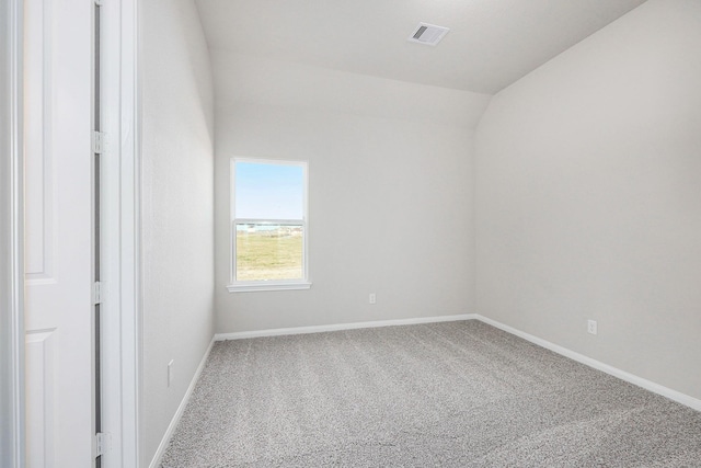 carpeted spare room with lofted ceiling