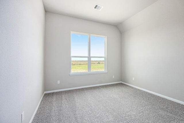 empty room with carpet flooring and vaulted ceiling