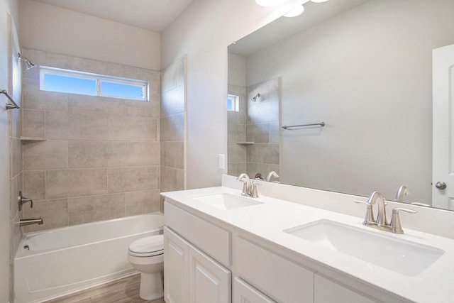 full bathroom with vanity, toilet, tiled shower / bath, and hardwood / wood-style flooring