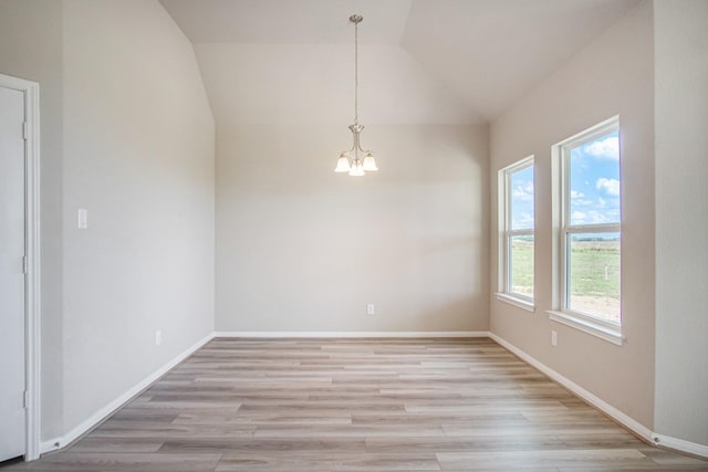 unfurnished dining area with plenty of natural light, light hardwood / wood-style flooring, a chandelier, and vaulted ceiling