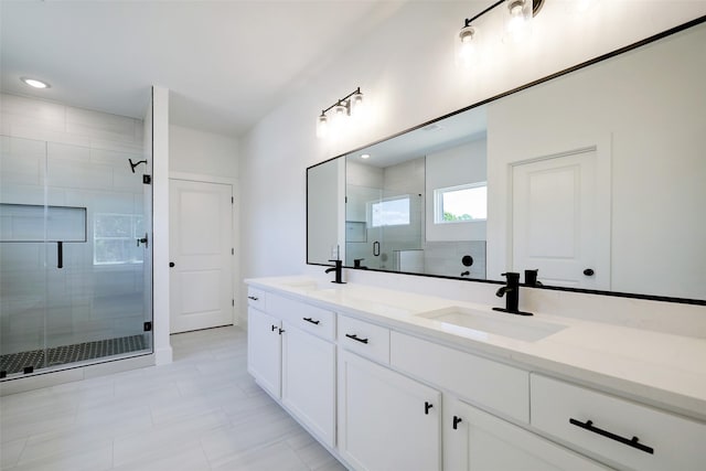 bathroom featuring a shower with door and vanity