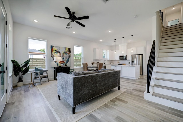 living room with ceiling fan and light wood-type flooring