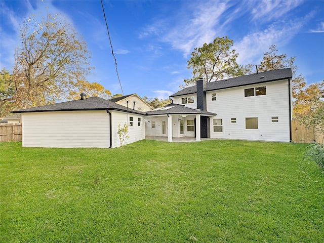 rear view of house featuring a yard and a patio area