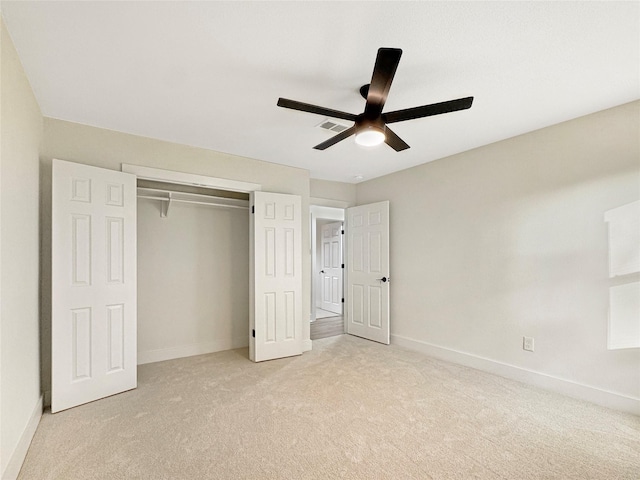 unfurnished bedroom featuring light carpet, a closet, and ceiling fan