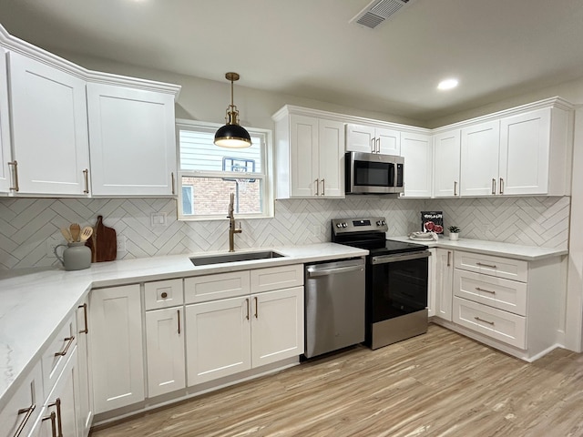 kitchen featuring sink, white cabinets, and appliances with stainless steel finishes