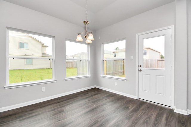 unfurnished dining area featuring dark hardwood / wood-style floors and a chandelier