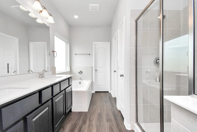 bathroom featuring vanity, wood-type flooring, and plus walk in shower