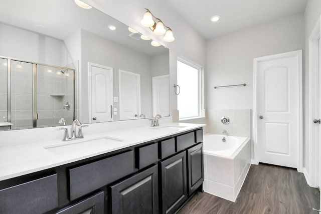 bathroom with wood-type flooring, vanity, and independent shower and bath