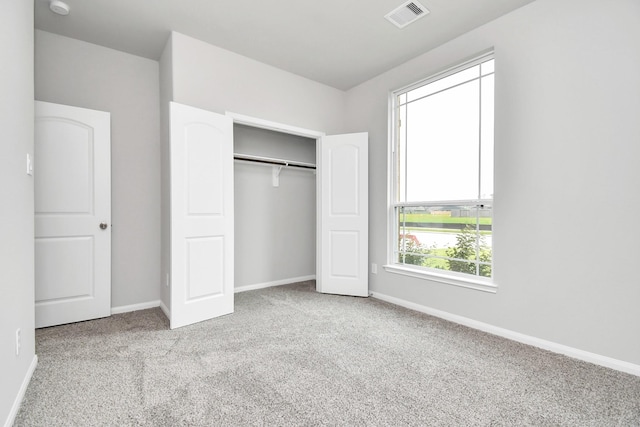 unfurnished bedroom with a closet and light colored carpet