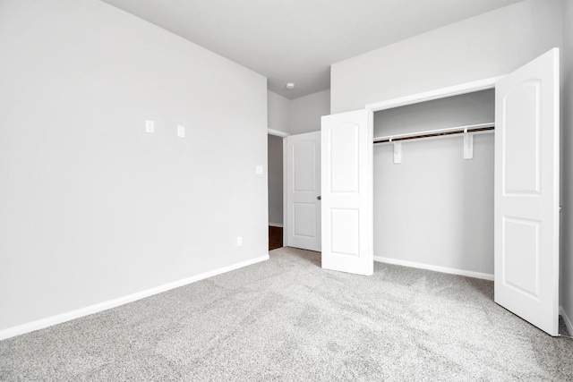 unfurnished bedroom with a closet and light colored carpet