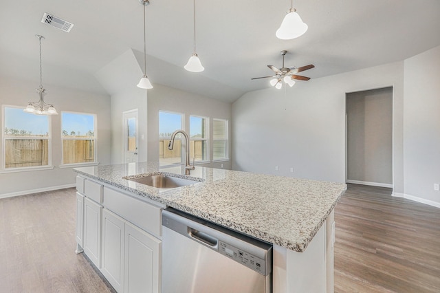 kitchen featuring light wood-type flooring, stainless steel dishwasher, vaulted ceiling, sink, and white cabinets