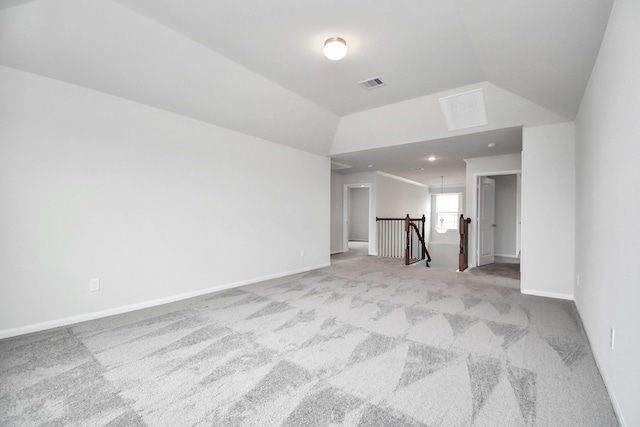 carpeted empty room with vaulted ceiling