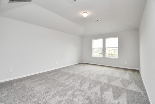 carpeted empty room featuring lofted ceiling