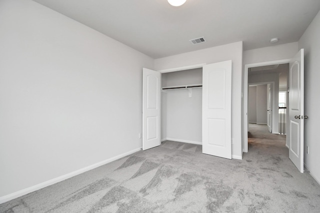 unfurnished bedroom featuring light carpet and a closet