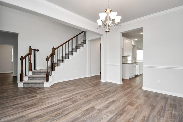 unfurnished living room with hardwood / wood-style floors, crown molding, and a chandelier