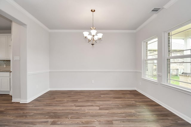 empty room with ornamental molding, an inviting chandelier, and dark wood-type flooring