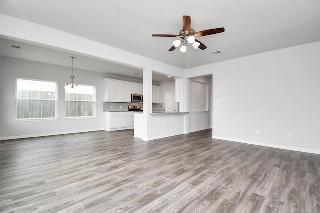 unfurnished living room featuring ceiling fan with notable chandelier, light hardwood / wood-style floors, and sink