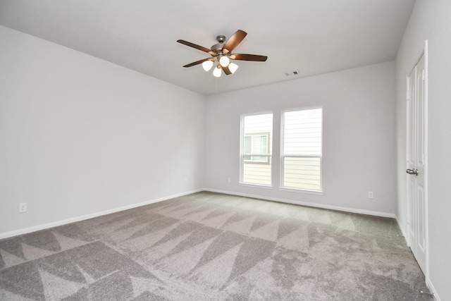 spare room featuring light carpet and ceiling fan