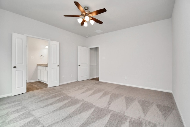 unfurnished bedroom with ceiling fan, carpet floors, and ensuite bath