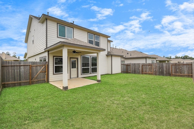 back of property with a patio area, ceiling fan, and a yard