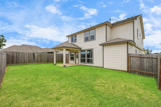 back of house with a yard and a patio