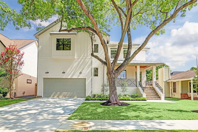 view of front of home featuring a porch, a garage, and a front yard