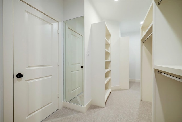 walk in closet featuring light carpet