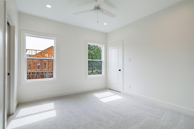 carpeted spare room featuring ceiling fan