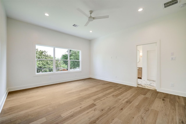 empty room with ceiling fan and light hardwood / wood-style floors