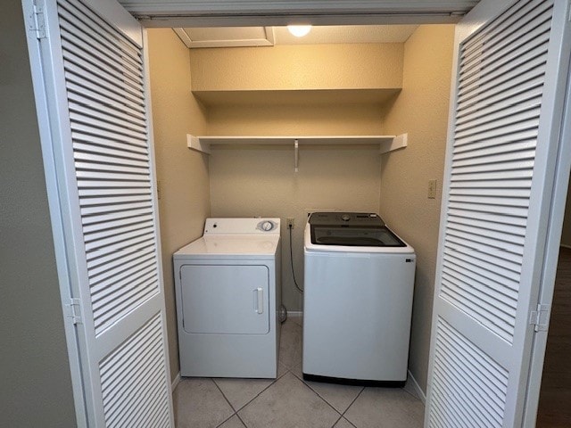 laundry room featuring washer and clothes dryer and light tile patterned floors