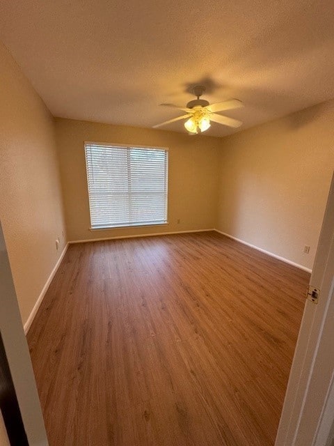 spare room with hardwood / wood-style flooring, ceiling fan, and a textured ceiling