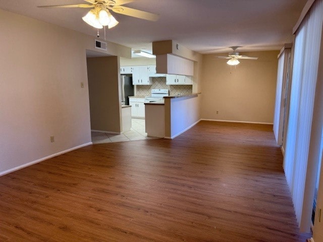 unfurnished living room with ceiling fan and light hardwood / wood-style floors