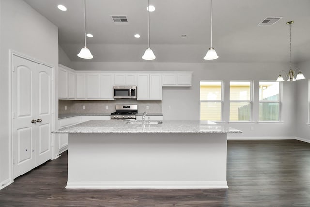 kitchen with white cabinets, appliances with stainless steel finishes, an island with sink, and sink