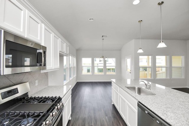 kitchen featuring plenty of natural light, light stone countertops, sink, and appliances with stainless steel finishes