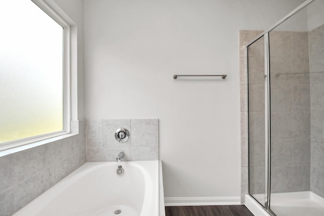 bathroom featuring plus walk in shower and hardwood / wood-style flooring