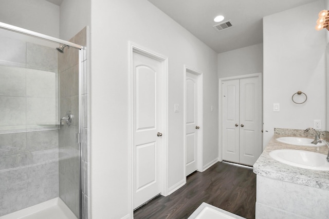 bathroom featuring hardwood / wood-style floors, vanity, and a shower with door