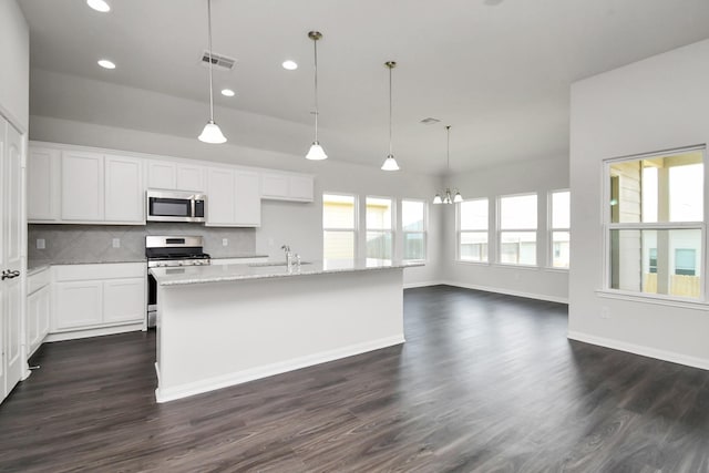 kitchen with white cabinets, appliances with stainless steel finishes, plenty of natural light, and hanging light fixtures