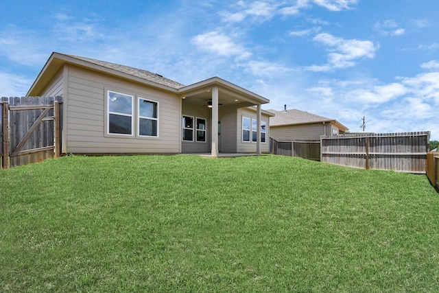 back of house featuring a lawn and ceiling fan