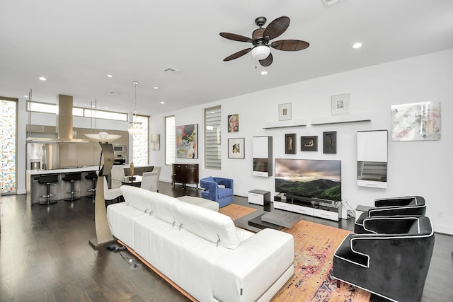 living room featuring ceiling fan and dark wood-type flooring