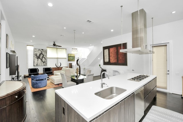 kitchen featuring stainless steel appliances, island range hood, sink, a center island with sink, and dark hardwood / wood-style floors