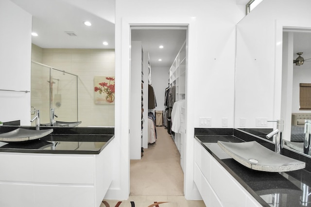 bathroom with tile patterned floors, a shower with door, and vanity