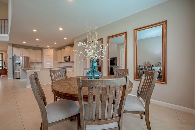 tiled dining room featuring an inviting chandelier and sink