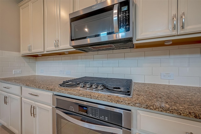 kitchen featuring backsplash, light stone counters, white cabinets, and appliances with stainless steel finishes