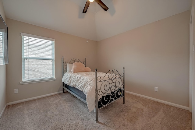 carpeted bedroom with ceiling fan and vaulted ceiling