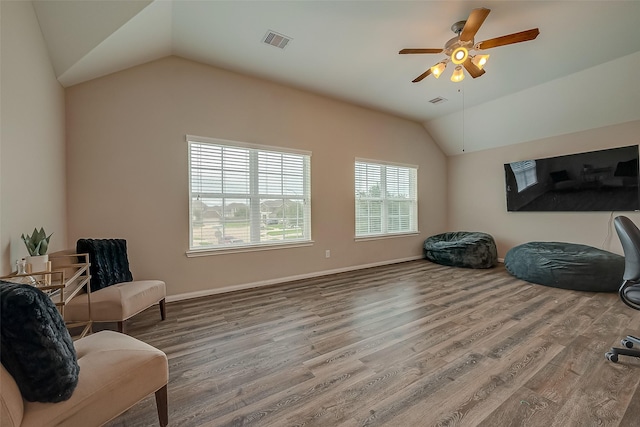 living area with wood-type flooring, ceiling fan, and lofted ceiling